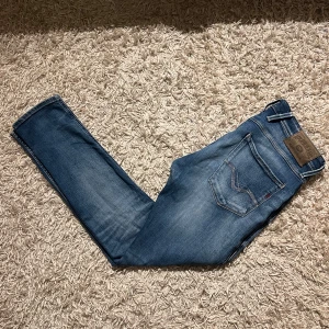 Replay anbass blå herr jeans med slitningar - Säljer ett par blå Replay Anbass jeans med slim  passform och snygga slitningar. Mycket bra skick, inga  märkvärdiga anmärkningar. Storlek 31 mått kan såklart skickas vid osäkerhet. Postas antigen samma dag som köp eller dagen därpå, billigare ifall man kan mötas🙌💯