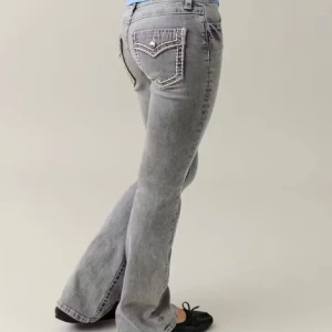 Grå bootcut jeans med detaljer - Snygga grå jeans med bootcut passform och coola fickdetaljer bak. Jeansen har en klassisk femficksdesign, normal midja och är tillverkade i mjukt denim. Perfekta för dig som gillar en avslappnad men trendig look. Har tyvärr ingen bild me de på då de är för små, slutsålda.