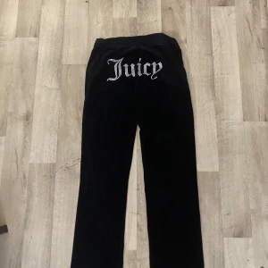 Svarta velourbyxor Juicy Couture M - !pris diskuteras!Svarta mjukisbyxor från Juicy Couture i velour med strassdetaljer. Stora glittriga 'Juicy' på baksidan och JC-logga framtill. Byxorna har snörning i midjan och klassisk relaxed passform. Perfekta för en chill och trendig look. Är 168 och dem är lite längre men skulle säga att dem passar perfekt ❤️ använt dem några gånger. Tvättas såklart innan leveransen ❤️