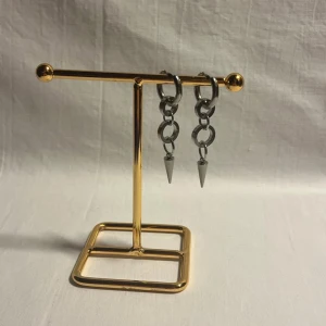 Silvriga örhängen med kedjor och spikes - Säljer ett par coola silvriga örhängen med kedjor och spetsiga spikes längst ner. Örhängena har ringar i metall som är sammankopplade och ger en edgy vibe. Perfekt för dig som gillar att sticka ut med din stil.