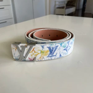 Vitt Bälte - Vitt bälte med färgglada mönster. 105cm långt. 