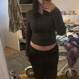 Svart långärmad topp - Säljer en svart långärmad topp i storlek L. Tillverkad av 95% polyester och 5% elastan, vilket ger en stretchig och bekväm passform. Perfekt för en stilren look.