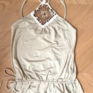 Beige topp med pärlor - Supersnygg beige  topp med dekorativa pärlor och snörning!! I gott skick men några av pärlorna är lösa (se sista bild), från märket KOOKAÏ i storlek 1 (jag bär vanligen s)