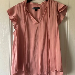 Rosa blus - Supersöt rosa blus från Banana Republic med v-ringning och korta volangärmar. Den har en liten fläck på framsidan men syns knappt 💞