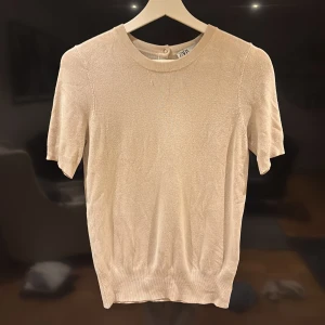 Beige kortärmad topp från Zara - Säljer en stilren beige topp från Zara med korta ärmar. 