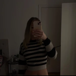 Randig croppad tröja - Säljer en snygg randig croppad tröja i svart och beige. Tröjan har långa ärmar och en bra passform som passar perfekt på mig. 