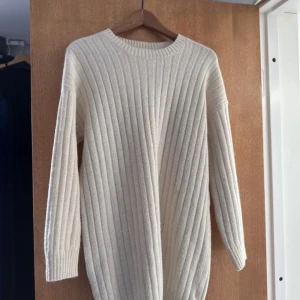 Vit ribbad stickad klänning  - Säljer en vit stickad kläning med ribbad struktur. Klänningen har långa ärmar och en klassisk rund halsringning. Perfekt för kyliga dagar men du fortfarande vill vara lite fin 