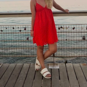 Röd  klänning - Snygg röd klänning med broderade detaljer och v-ringning. Använd men mycket fint skick❣️lätt att anpassa till bysten pga snören där bak.