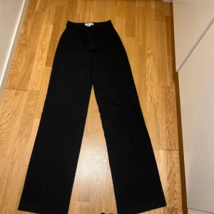 Svarta kostymbyxor - Snygga svarta kostymbyxor med hög midja och rak passform. Perfekta för en stilren look.