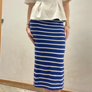Blå och vit randig kjol - Snygg blå och vit randig kjol i stickat material. Kjolen har en tight passform och når till knäna. Perfekt för en stilren look.