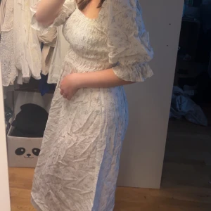 Vit klänning med puffärmar - Jättesöt sommarklänning med puffärmar och små blommor i lila och grönt. 