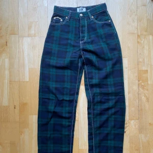 Eytys Benz Tartan stl 24 - Gröna och svarta rutiga byxor från Eytys i modellen Benz med hög midja och oversized fit. Stl 24/34. Sparsamt använda och i gott skick. Skickas från Berlin, frak tillkommer :)