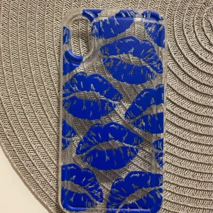 Mobilskal med blå läppar - Snyggt mobilskal med genomskinlig bas och blå läppar som mönster. Perfekt för att ge din telefon en unik och trendig look. Ska vara till en IPhone X