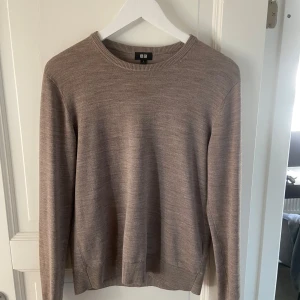 Merinoull tröja från uniqlo - Säljer en stilren beige stickad tröja från Uniqlo. Tröjan har en rund halsringning och långa ärmar. Den är tillverkad i mjuk merinoull  som ger en skön känsla mot huden. Mycket bra skick förutom en lagning vid ena axeln men som knappt syns. Storlek S. Hör av er vid frågor! Pris kan diskuteras😁