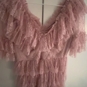 Rosa spetsklänning från By Malina - Säljer en romantisk rosa spetsklänning från By Malina. Använd en gång! Klänningen har volanger och en v-ringad design med korta ärmar. Perfekt för speciella tillfällen. Pris kan diskuteras 💖