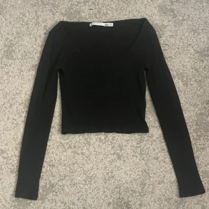 Svart ribbad topp XS - Snygg svart ribbad topp med långärmad design. Perfekt för en stilren look. Passar bra till både jeans och kjol. Från lager 157 i storlek XS