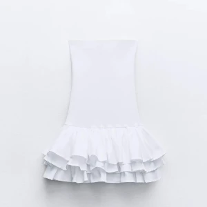 Vit klänning med volangdetaljer - Vit klänning med volangdetaljer i nederkant. Klänningen är från Zara i storlek S. Den är perfekt för sommar och student och är i nyskick. 