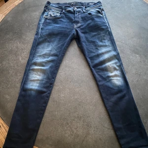 Mörkblå jeans från Replay - Snygga mörkblå jeans från Replay i modellen Anbass. De har en slim passform och klassisk femficksdesign. Jeansen har en lätt tvättad look för en trendig stil. Storlek 30/31