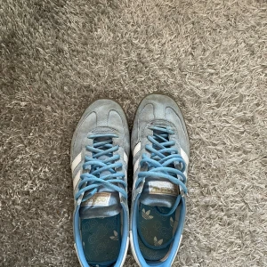 Adidas spezial skor  - Snygga blå sneakers från Adidas med vita ränder och ljusblå snörning. Skorna har en klassisk design med en gummisula som ger bra grepp. Perfekta för en avslappnad stil. Storleken är 42/5 och passar mig perfekt jag som har de. Utmärkta nu till våren och sommaren 