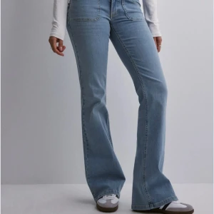 lågmidjade jeans - Snygga ljusblå bootcut jeans med låg midja och klassisk femficksdesign. Jeansen har fickor med knappar där bak. Aldrig använda, nya men utan prislapp. Nytt skick☺️