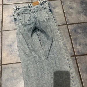 Ljusa jeans med hög midja - Säljer ett par ljusa jeans med hög midja och klassisk femficksdesign. Jeansen har en rak passform och är tillverkade i denim. 