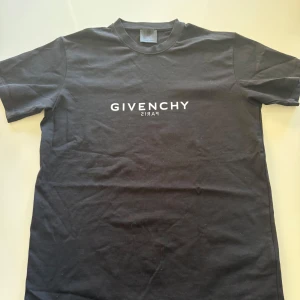 Svart t-shirt från Givenchy - Snygg svart t-shirt från Givenchy med vit logotyp på bröstet. Perfekt för en stilren look. Tillverkad i mjukt material för extra komfort.
