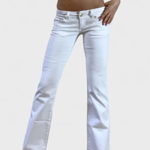 Interesse koll bootcut jeans från G.Rise - Intressekoll på mina snygga vita bootcut jeans från G.Rise med broderad logga i rosa på fickan. De har låg midja och dekorativa knappar på bakfickorna. Perfekta för en stilren look.