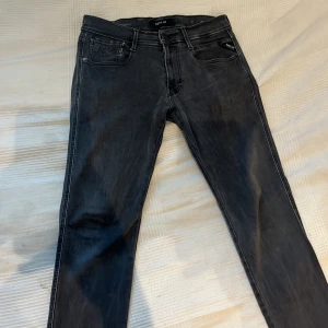 Grå Replay Hyperflex Anbass Jeans - Snygga grå jeans från Replay i modellen Hyperflex Anbass. De har en normal passform med dragkedja och knapp framtill. Perfekta för en stilren look med klassiska femficksdetaljer.