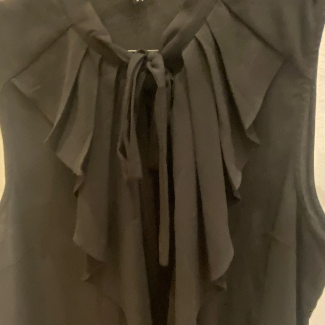 Svart ärmlös blus med volang och knyt - 1