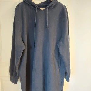 Mörkblå hoodie från Ellos - Mysig och enkel mörkblå hoodie från Ellos med huva och dragsko. Tröjan har långa ärmar och en avslappnad passform, perfekt för en chill stil. Passar dig som gillar bekväma och stilrena plagg.