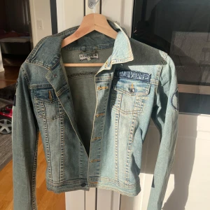 Ljusblå jeansjacka med tryck från 5 Preview - Säljer en ljusblå jeansjacka från Preview med coolt 'WHATEVER'-tryck på ryggen och dekorativa bröstfickor med knappar. Klassisk krage och snygga sömdetaljer. Perfekt för dig som vill sticka ut lite extra. Strl xs