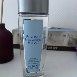 Beyoncé Shimmering Heat parfym spray - En fräsch och elegant parfym spray från Beyoncé, Shimmering Heat. Flaskan är genomskinlig med en ljusblå etikett och silverfärgat lock. Passar dig som gillar en modern och feminin doft.