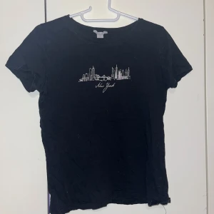 T-paita - Naisten musta t-paita. Edessä kuvio. Koko M.  Kaikai n  40cm, pituus n 55cm. Kissatalous MMM Mikäli hinta ei miellytä tarjoa rohkeasti Katsothan myös muut ilmoitukseni!!