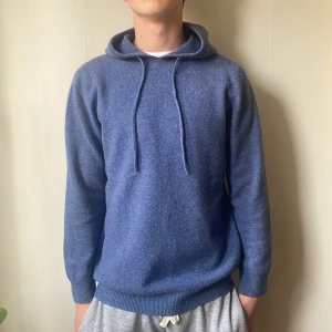 Blå merinoull hoodie - Snygg ljusblå merinoull hoodie med luva. Tröjan har långa ärmar och ribbade muddar. Perfekt nu till våren med en fet hoodie! Skriv vid minsta funderingar!