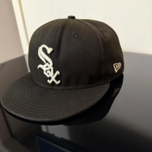 Svart keps från New Era 59FIFTY White Sox - Säljer en svart keps från New Era 59FIFTY med White Sox-logga framtill i vitt. Klassisk modell med broderad logotyp på sidan och baksidan. 