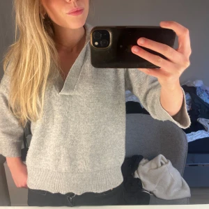 Ljusgrå stickad tröja med krage från H&M - Säljer en ljusgrå stickad tröja från H&M med v-ringning och krage. Tröjan har trekvartsärm och bred ribbad mudd nedtill. Perfekt för lager-på-lager och enkel att matcha med jeans eller kjol. Skriv och fråga om det är något du undrar!💗💗