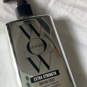 Color Wow Extra Strength Dream Coat - Color Wow Extra Strength Dream Coat är en fuktgivande spray i en silverfärgad pumpflaska. Produkten är framtagen för att ge extra styrka och glans till håret. Flaskan har en modern design med svart text och spegelblank yta.
