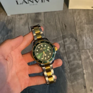 SO&CO herrklocka i guld och silver - Stilren herrklocka från SO&CO med tvåfärgat armband i guld och silver. Urtavlan är svart med gröna detaljer och tydliga markeringar. Klockan har en robust design och passar perfekt som accessoar. nypris på just denna klocka ligger på 3499 när jag köpte den. Det är bara att skriva vid frågor och funderingar 😁