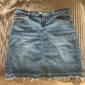 Blå jeanskjol med fransad kant - Säljer en superfin blå jeanskjol från 157 med fransad nederkant och femficksmodell. Kjolen är sparsamt använd. Storlek S.