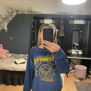 Blå sweatshirt med gult vancouver tryck - Säljer en blå sweatshirt med stort gult tryck framtill där det står 'Vancouver Vultures'. Använd några få gånger. 