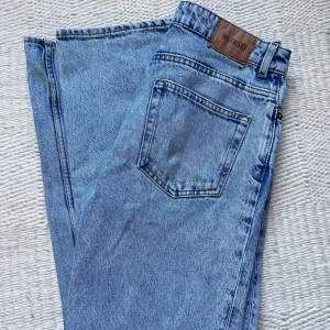 Blå  jeans från Weekday - Säljer ett par klassiska blå jeans från Weekday, modell Voyage. Jeansen har raka ben, fem fickor och normal passform. De är tillverkade i denim och har en snygg ljusblå tvätt. Perfekta till vardags och lätta att matcha med olika stilar.