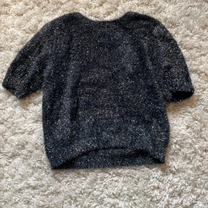 Svart glittrig tröja från Kappahl - Säljer en svart glittrig stickad tröja från Kappahl i str 158/164. Tröjan har kortare ärmar och är gjord i ett fluffigt, stickat material med massa glitter. Perfekt till en fest eller till ett glittrigt tema. Använt endast 1 gång. Orginalpris 300kr. Pris kan diskuteras 💗
