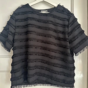 Svart topp med fransdetaljer från H&M - Tröja från H&M i stl 40, sitter som en M-L, köptes från Sellpy men aldrig använd så i ett bra skick. Skriv om du har fler frågor 💗