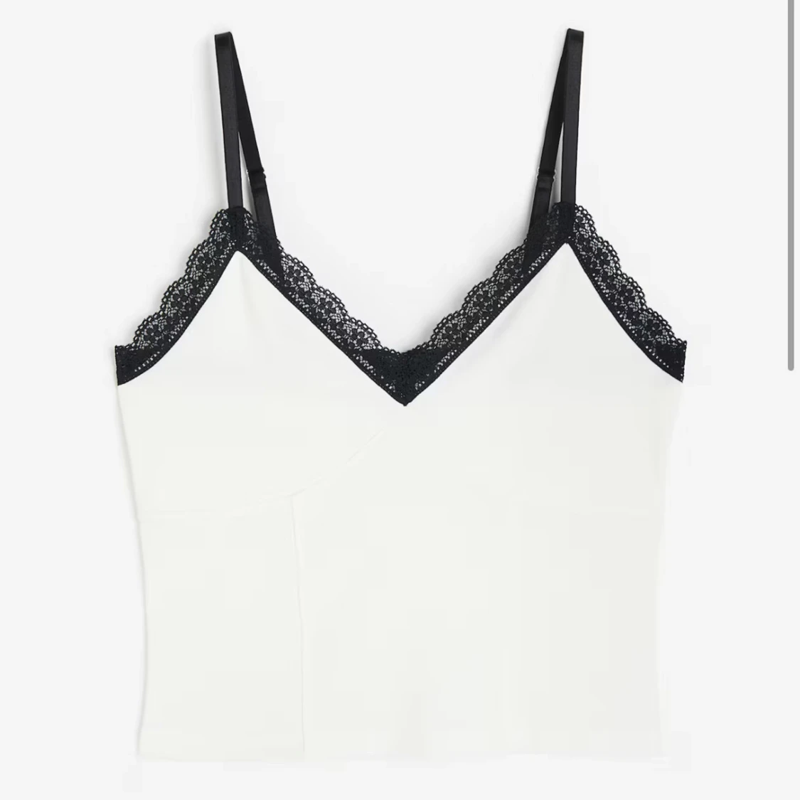 Vit linnetopp med svarta spetsdetaljer