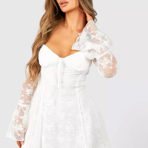 Vit klänning med blommiga spetsärmar - Superfin vit klänning. Helt oanvänd och prislappen kvar. Köpt för 750kr