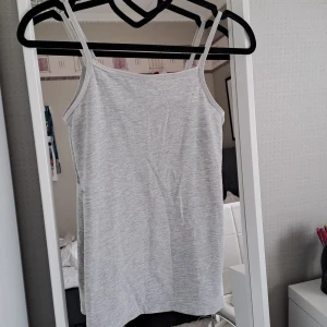 Ljusgrått linne från H&M - Säljer ett enkelt och stilrent ljusgrått linne från H&M. Linnet har smala axelband och är perfekt för varma dagar eller som lager under andra plagg. Mjukt material och klassisk passform. Aldrig använd, säljer för att den ej har kommit till användning. 🎀