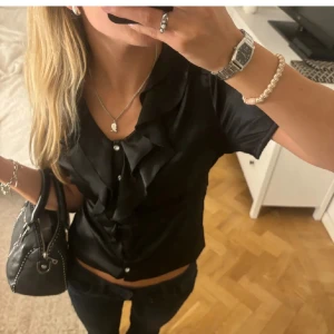 Svart topp med volang och knappar - Supersnygg topp med volang!!💕 jättefin men kommer tyvärr inte till användning🥲🥲💖