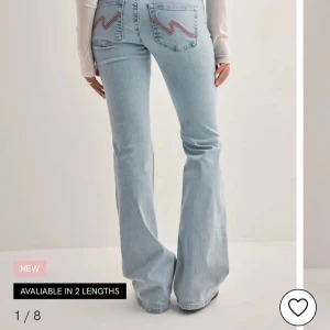 Bootcut jeans med broderade fickor - Ljusblå bootcut jeans med slitna knän och snygga rosa broderier på bakfickorna. Bara användt 2gånger och som ny skicka där jag ska sälja dom pågrund av används inte nya kostar 700kr