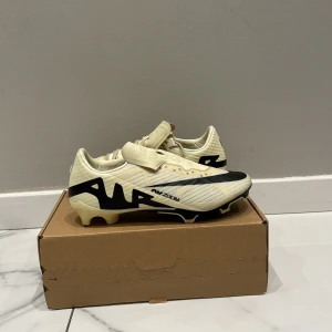 Nike Air Zoom fotbollsskor beige/svart - Snygga air zoom fotboll skor som är använda 2 gånger bara som kommer med två olika färger av snören ett par vita ett par gula till båda skorna 