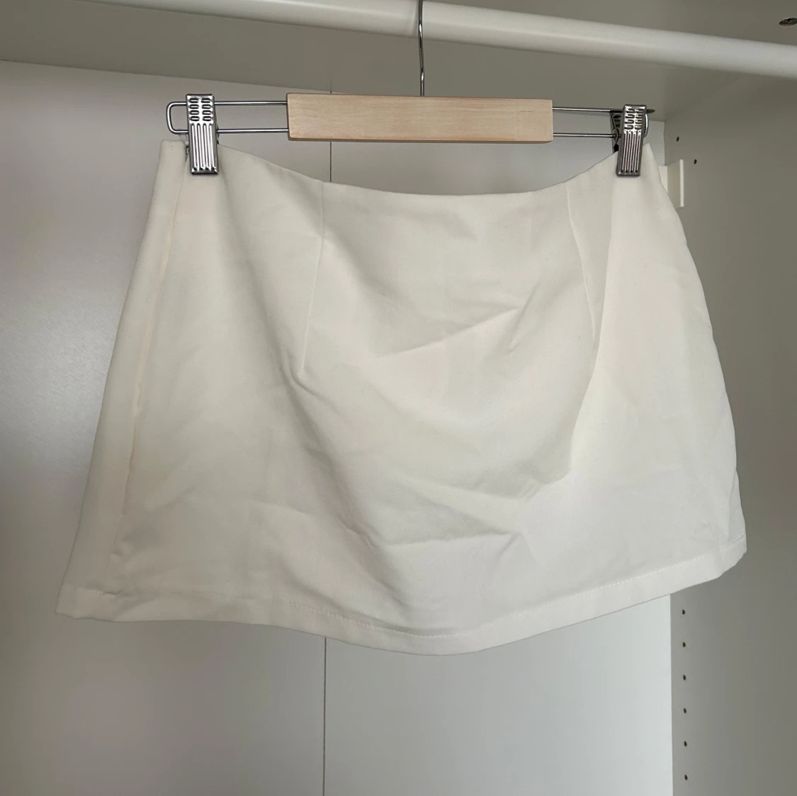 Vit kort kjol med insydda shorts